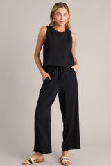 Full body view of this black top that features a crew neckline, a keyhole cutout with a functional button, and a back slit.