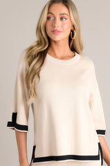Front view of this beige sweater top that features a crew neckline, a relaxed fit, split quarter sleeves, and contrasting split hemlines.
