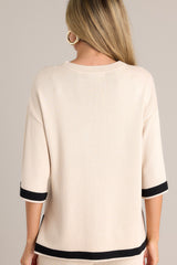 Back view of this beige sweater top that features a crew neckline, a relaxed fit, split quarter sleeves, and contrasting split hemlines.