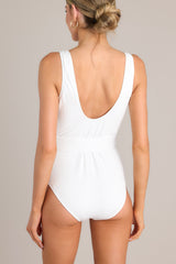 Back view of this one piece swimsuit that features a dual deep v-neckline, thick straps, an optional matching belt with a circular tortoise shell buckle, and an elastic hem.