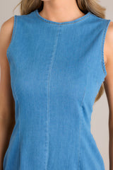 Close up view of this dress that features a high crew neckline, a keyhole cutout at the back of the neck, a seam down the middle, and a slit in the back hemline.