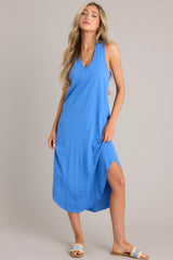 Front view of this blue dress that features a v-neckline, a seam down the front and back, a soft & lightweight material, and a scoop hemline.