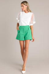 Full front view of this white top featuring a crew neckline, a soft stretchy fabric, and sheer short butterfly sleeves.