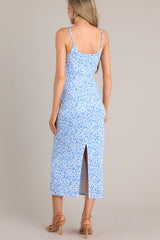 A back view of this blue dress that features a plunging neckline, a cutout detail in front, a slit at the back of the skirt, and a playful blue pattern.