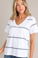 Angled view of this white tee that features a v-neckline, a soft lightweight fabric, and a twin stripe pattern.
