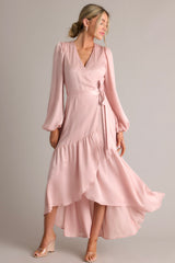Movement photo of this dusty pink wrap dress that showcases the asymmetrical flowy skirt.