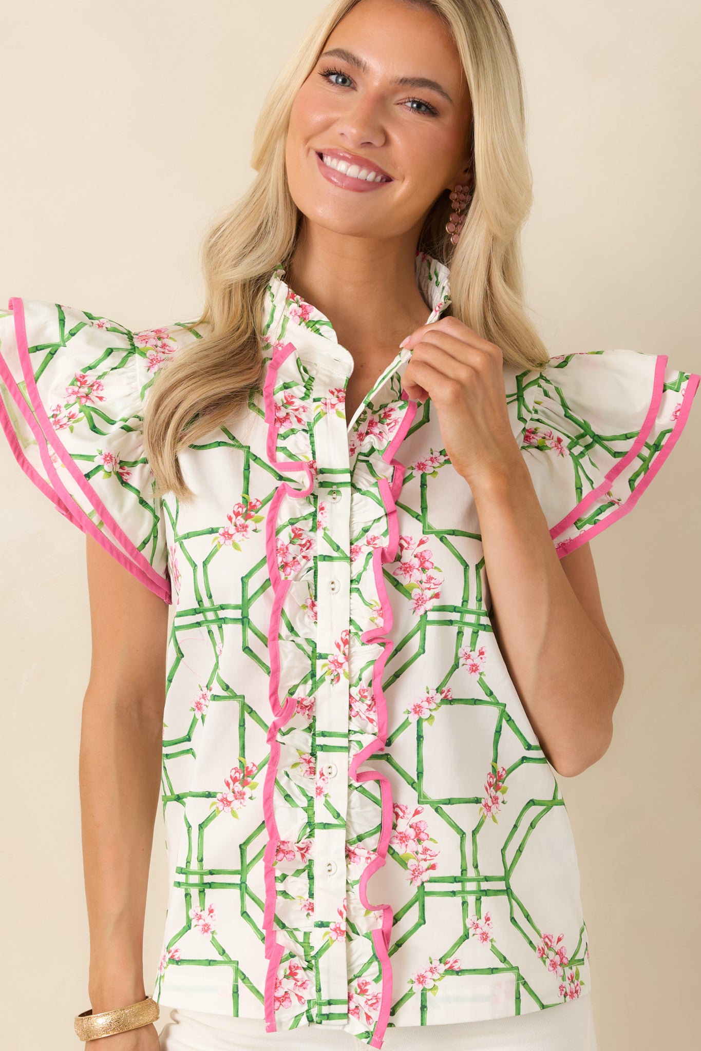 Pink and green printed blouse showcasing sleeve flutter detail and delicate trellis patterning.