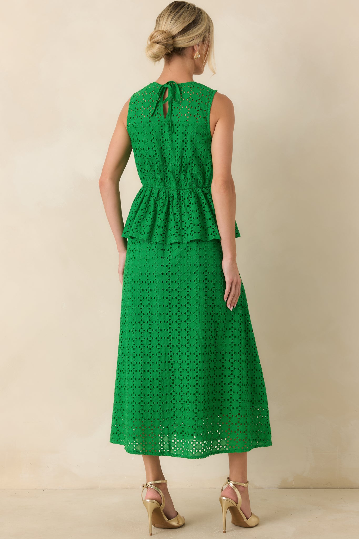 Rear view of the green eyelet midi dress featuring a keyhole back with tie closure, sleeveless cut, and flowing midi skirt.