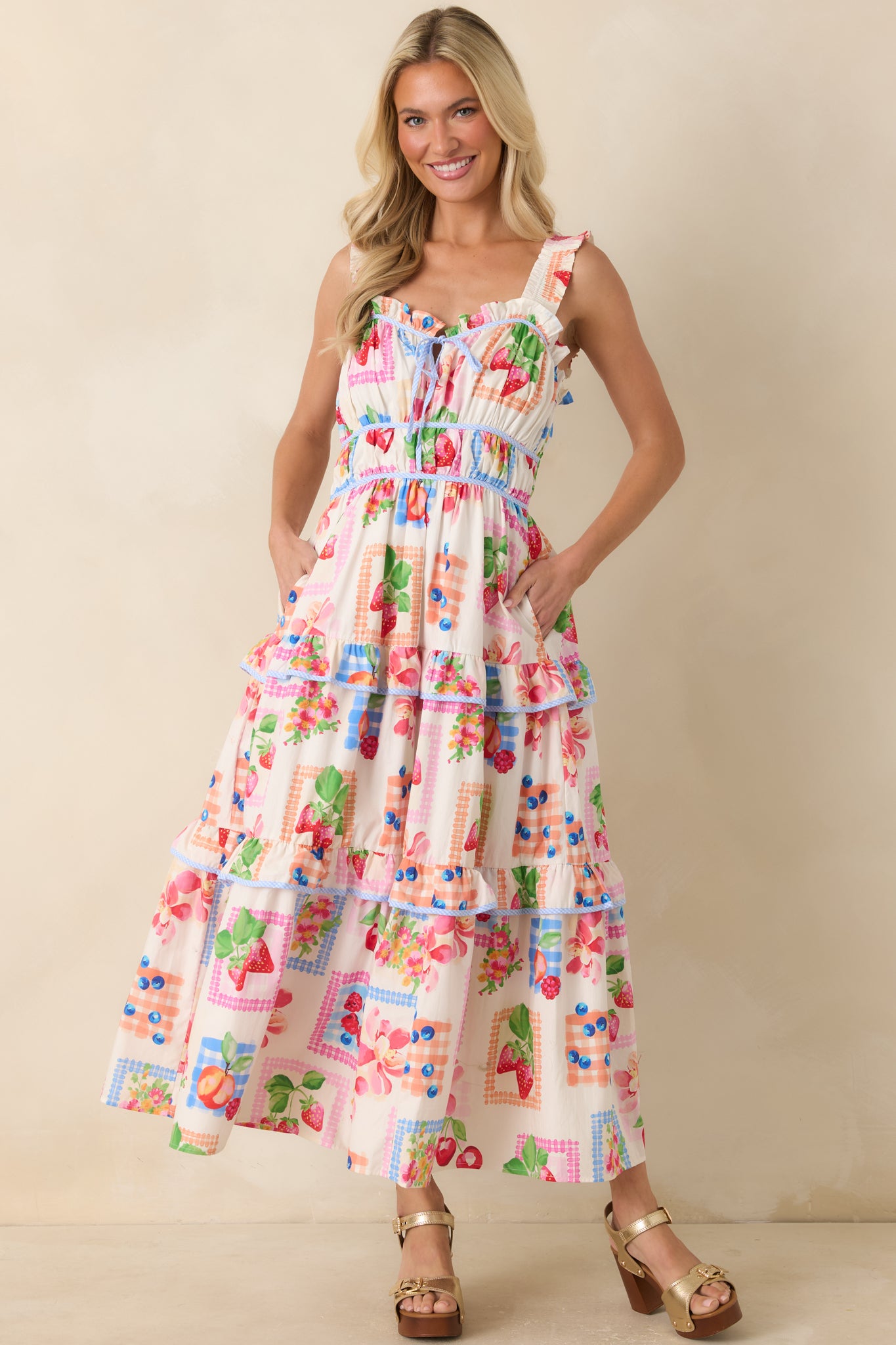 Vibrant patchwork maxi dress featuring a fitted bodice that flows into a tiered skirt with gingham-trimmed ruffle detailing.