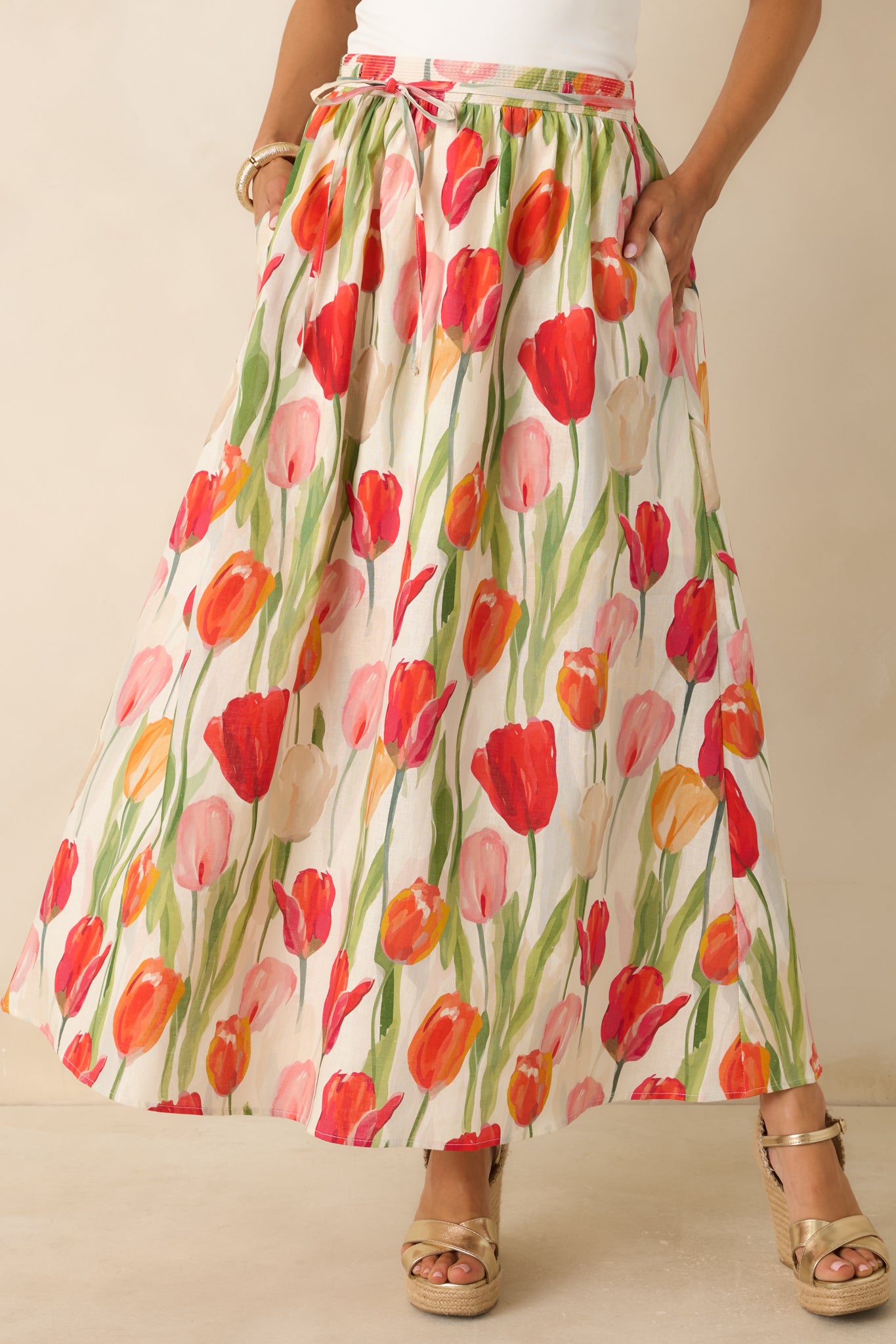Ivory and red tulip print skirt highlighting the self-tie waist detail, gathered elastic waistband, and soft drape.