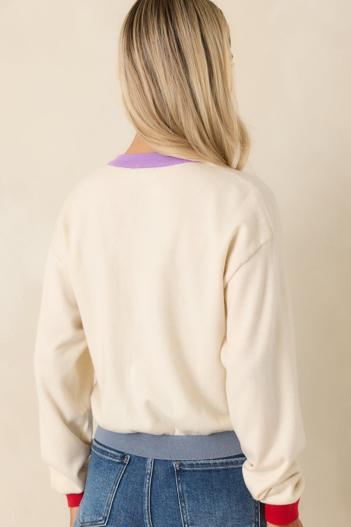 Rear view of ivory knit cardigan with relaxed silhouette and soft texture.