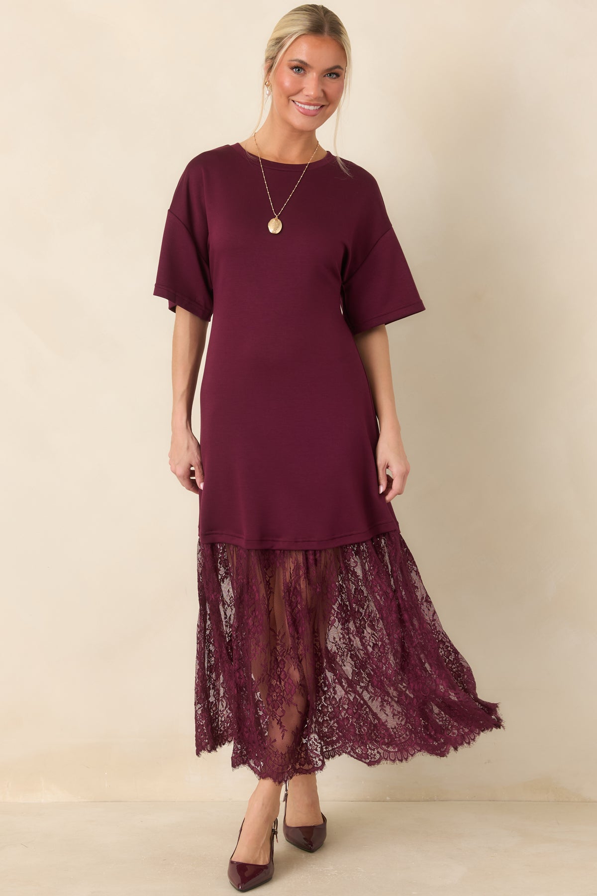 The rich plum midi dress features an opaque knit upper and a wide sheer lace panel with intricate floral detailing.