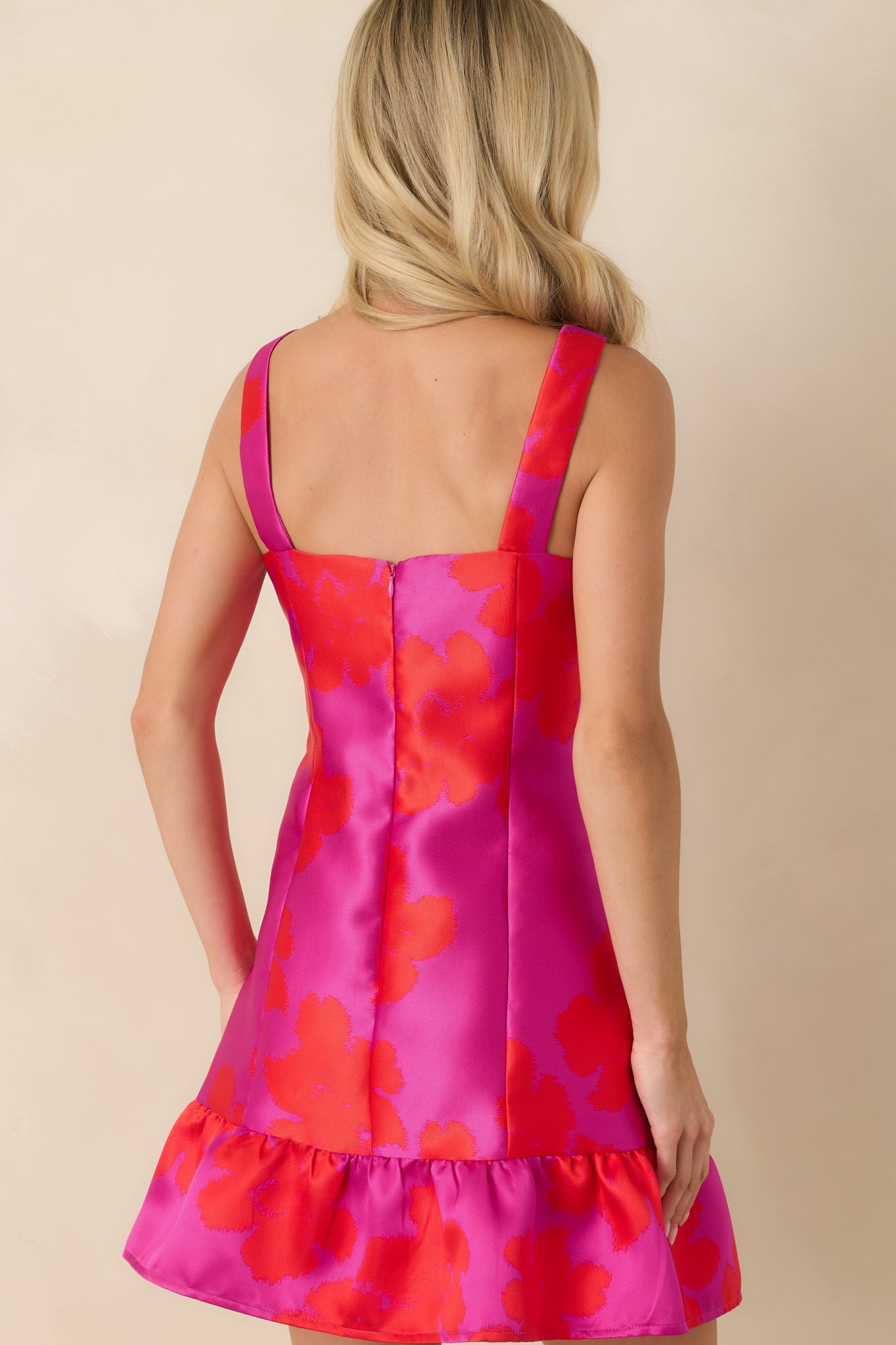 Rear view of the floral mini dress featuring a concealed back zipper closure and fitted structured silhouette.