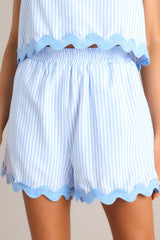 Light blue high-waisted shorts with an elastic waistband, functional pockets, and a charming thick ricrac hemline.