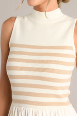 Close up view of this dress that features a high neckline, a striped sweater bodice, and a flowy skirt.