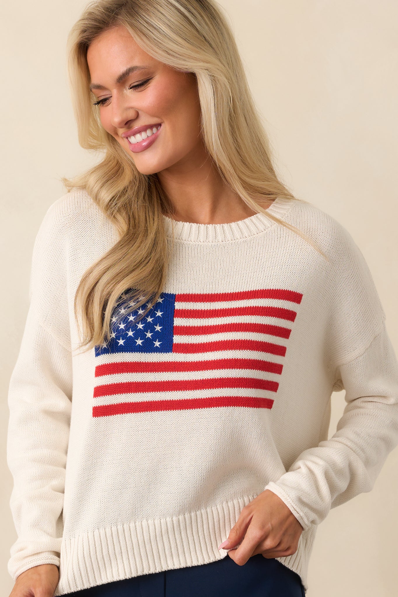 Midsection view focused on the embroidered chest and the soft, textured fabric of the ivory sweater.