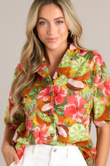 Close up front view of this coral tropical print top that features a collared neckline, fully functional buttons down the front, a citrus floral print design, and a slightly cropped fit.