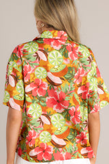 Back view of this coral tropical print top that features a collared neckline, fully functional buttons down the front, a citrus floral print design, and a slightly cropped fit.
