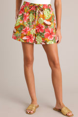 Front view of these coral tropical print shorts that feature a high waisted design, an elastic waistband, a self-tie drawstring, functional hip pockets, and a wide leg.
