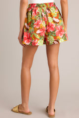 Back view of these coral tropical print shorts that feature a high waisted design, an elastic waistband, a self-tie drawstring, functional hip pockets, and a wide leg.