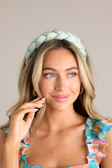 Front view of this headband that features a thick, soft material, and a braided texture.