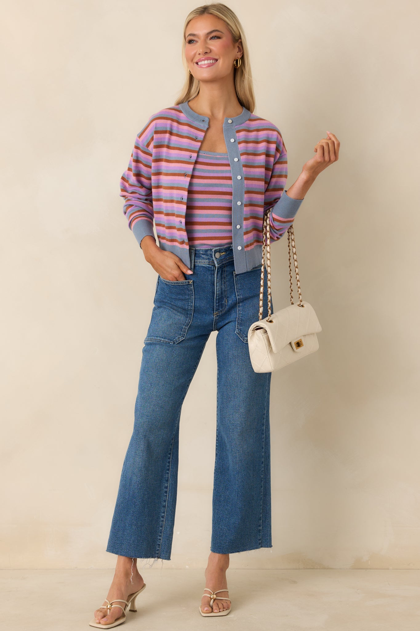 Striped knit cardigan with light blue, lilac, and rust tones and button front.