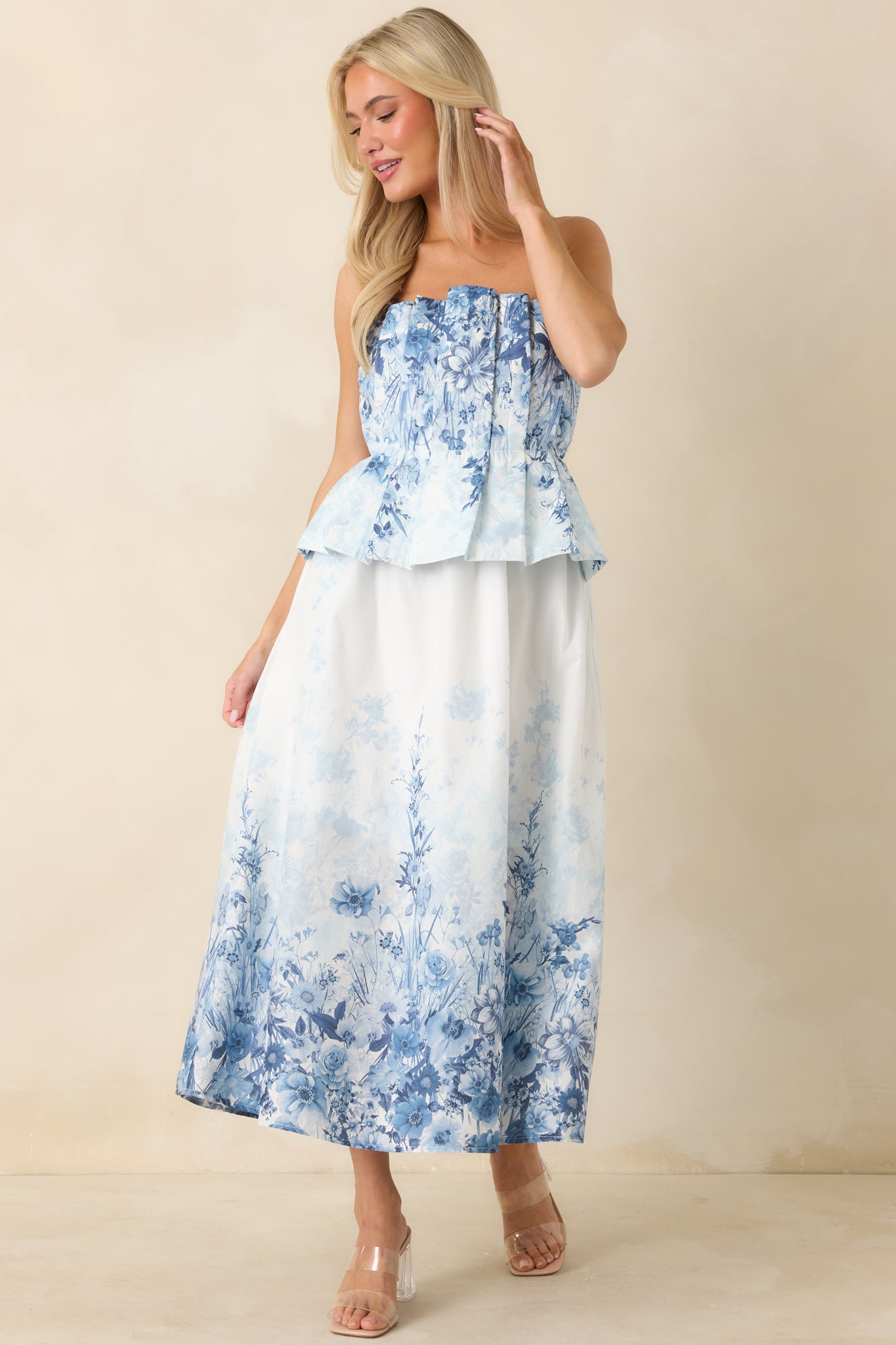 Blue floral midi dress with strapless neckline, side pockets, and relaxed skirt shape.