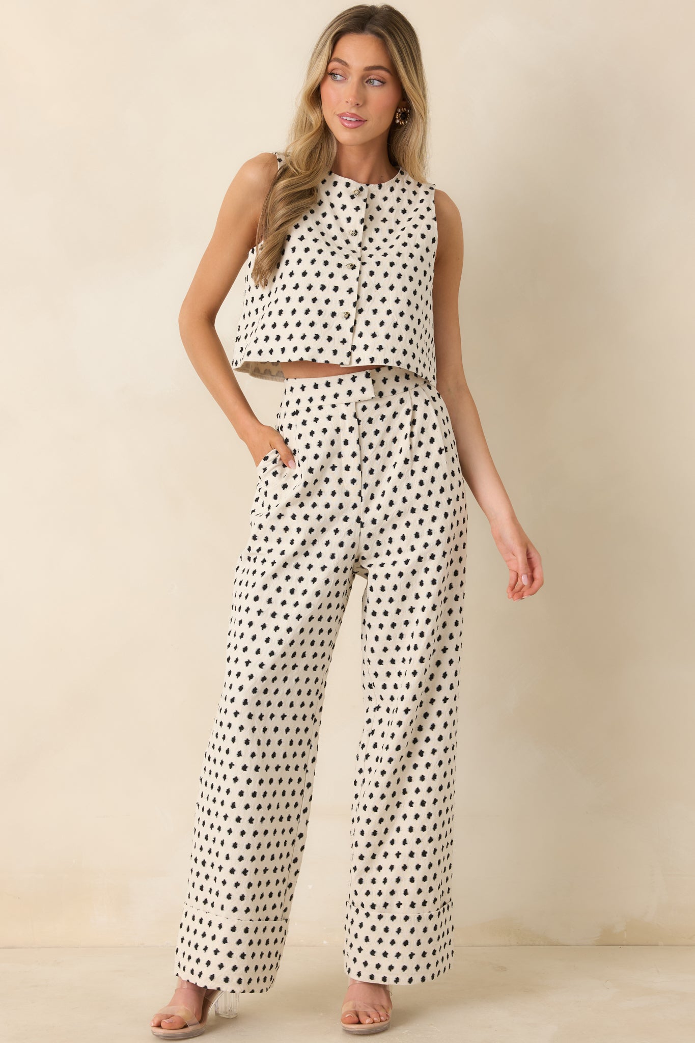 Ivory cotton-linen blend trousers with subtle black pattern, high-rise waist, and wide-leg silhouette.
