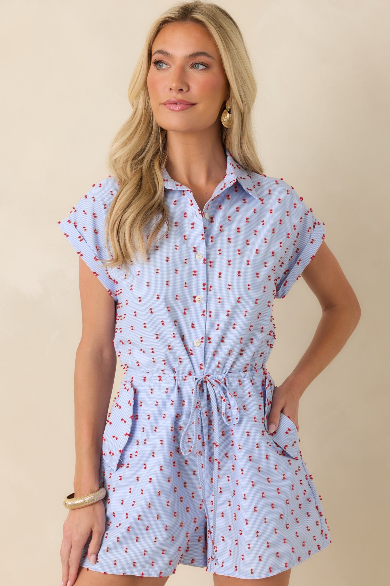 Detailed look at the elastic drawstring waist and red tufted embroidery across the gingham fabric.