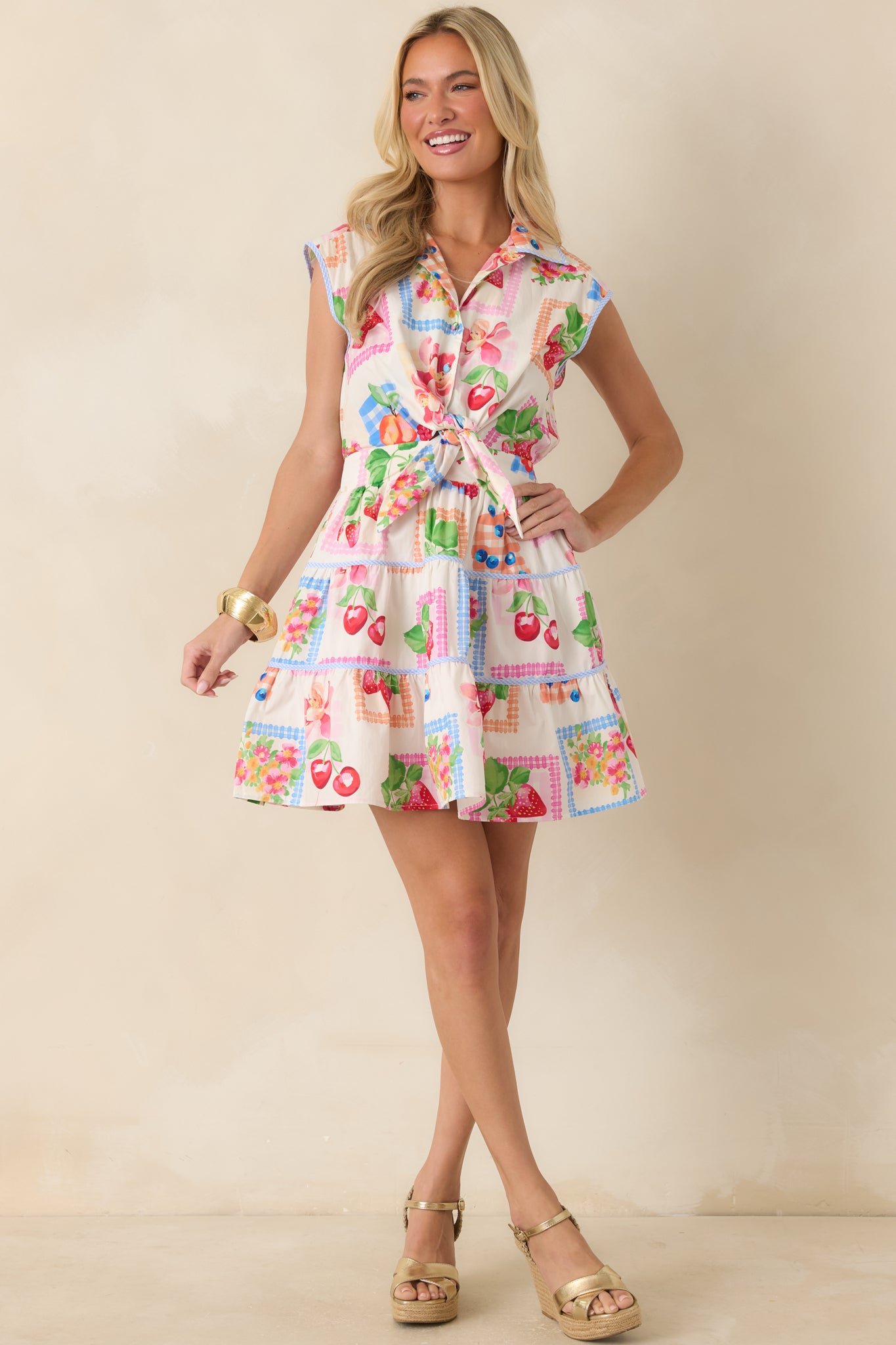 Fun printed mini dress with a structured collar, button closure, and a flouncy tiered mini-length skirt.