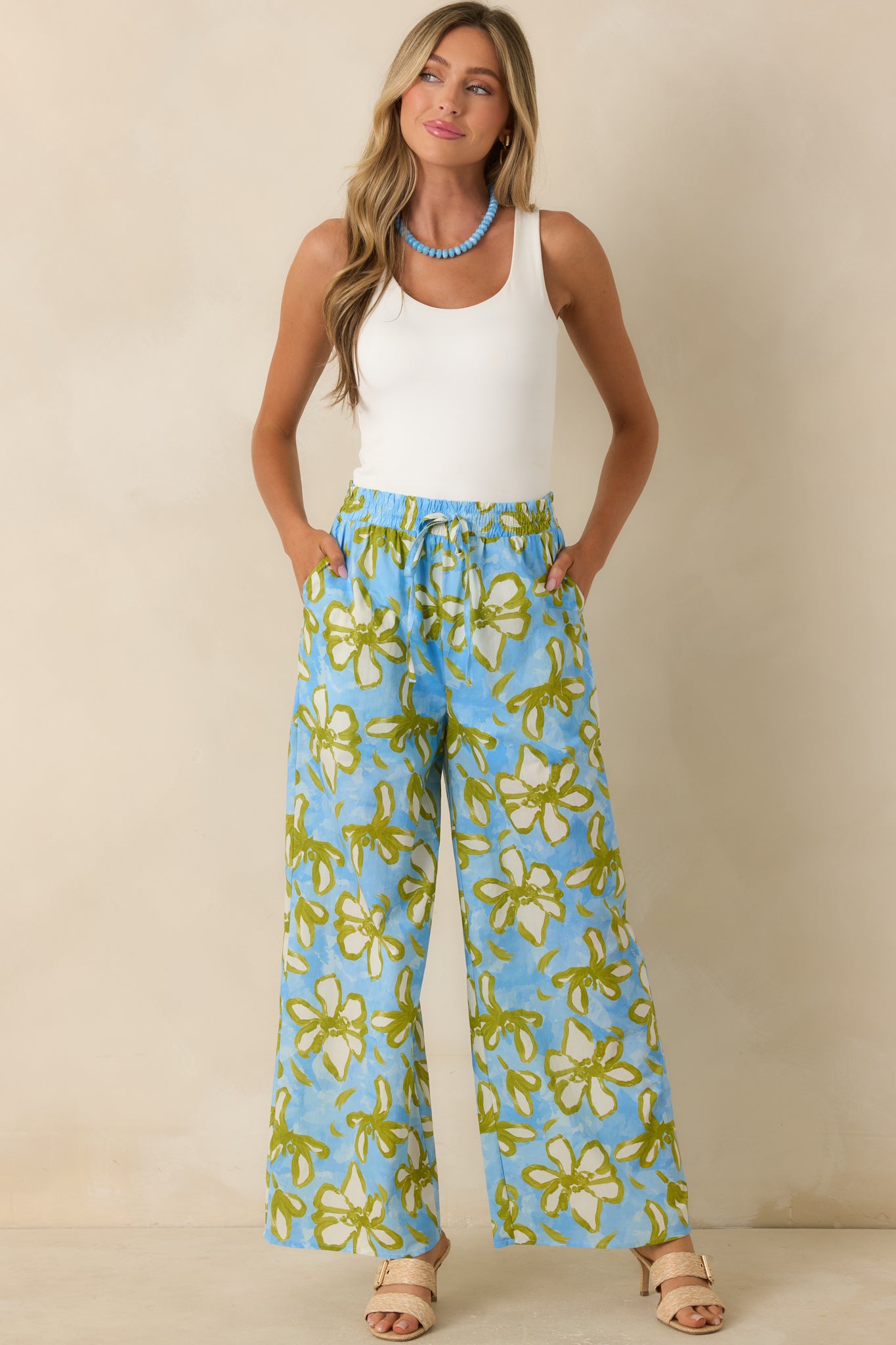 Sky blue, olive green, and ivory floral pants featuring a relaxed wide leg silhouette, elastic waistband, and flowing cotton fabric.