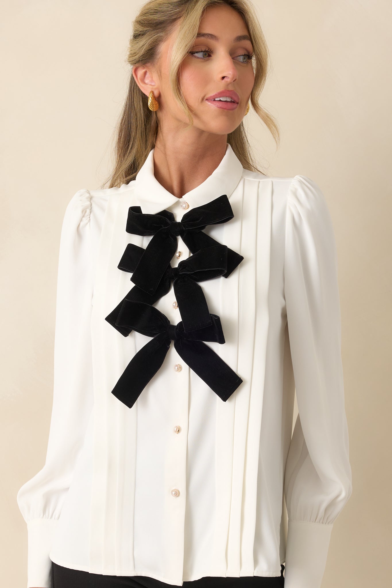 Minimalist white top highlighting the collared neckline, cuffed sleeves, and relaxed hip-length silhouette.