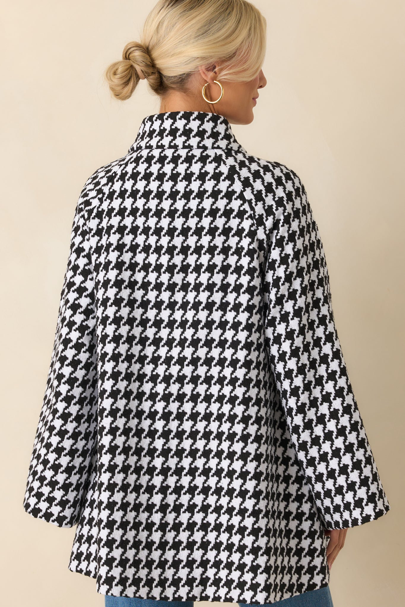 Rear view of the black-and-white houndstooth coat showing the smooth back panel and tailored hip-length silhouette.