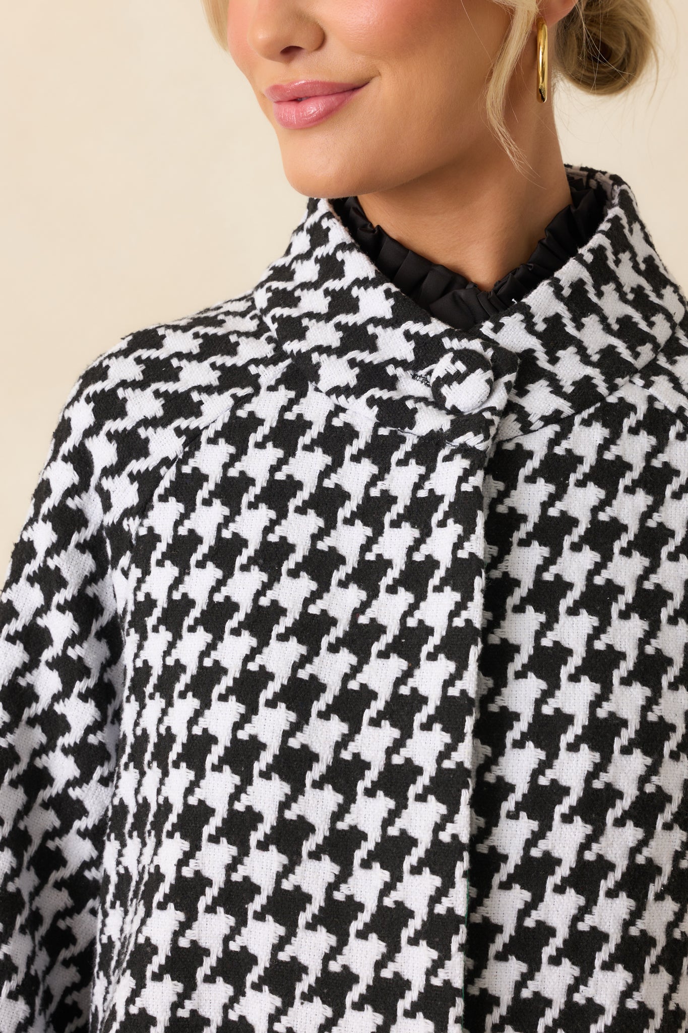 Close-up detail of the coat emphasizing the woven houndstooth pattern, front buttons, and pocket edges.
