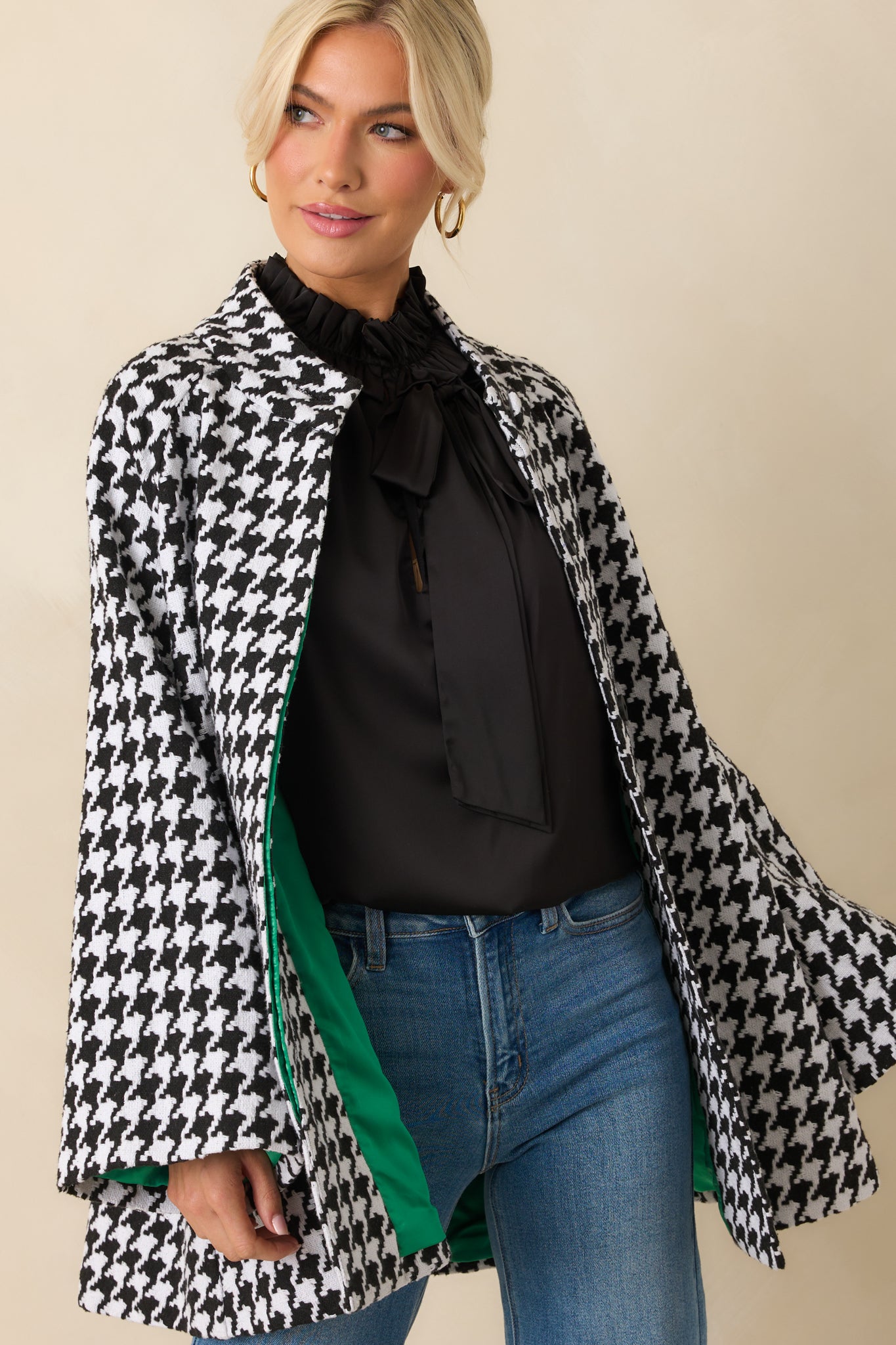 Cropped view of the black-and-white coat showing pocket placement, woven texture, and button detailing.
