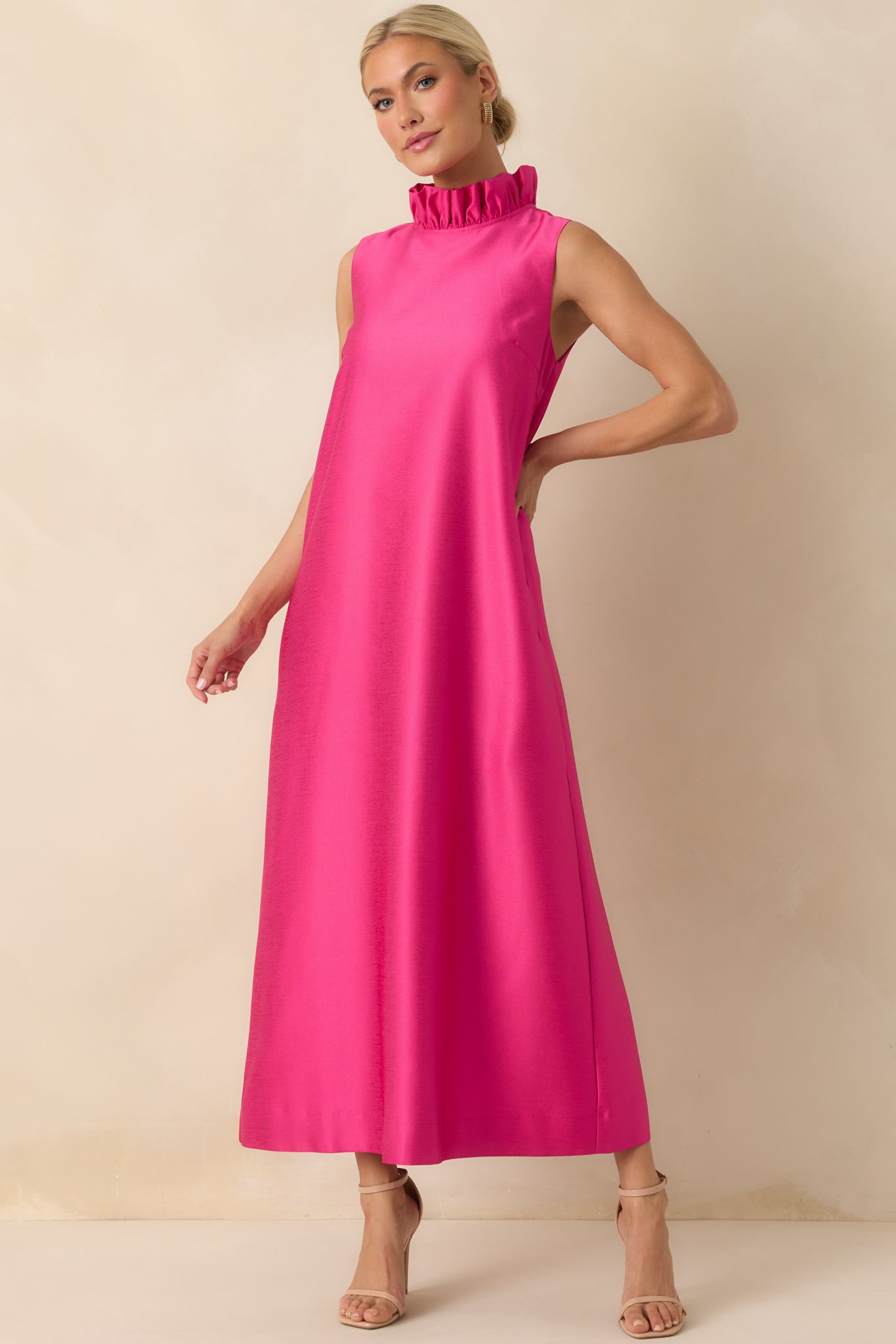 Flowing hot pink maxi dress featuring a straight drape, sleeveless design, and soft fabric texture.