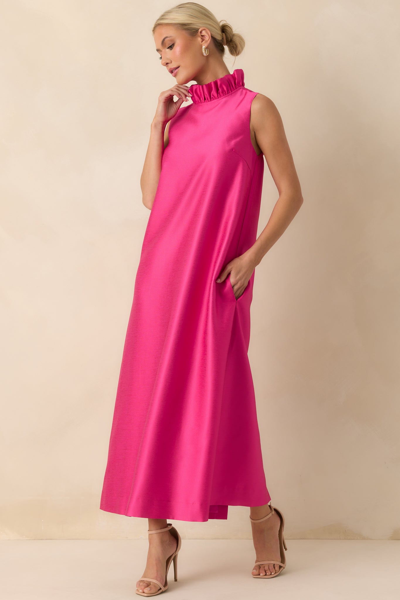 Hot pink sleeveless maxi dress with a ruffle mock neckline and smooth flowing fabric from shoulders to hem.