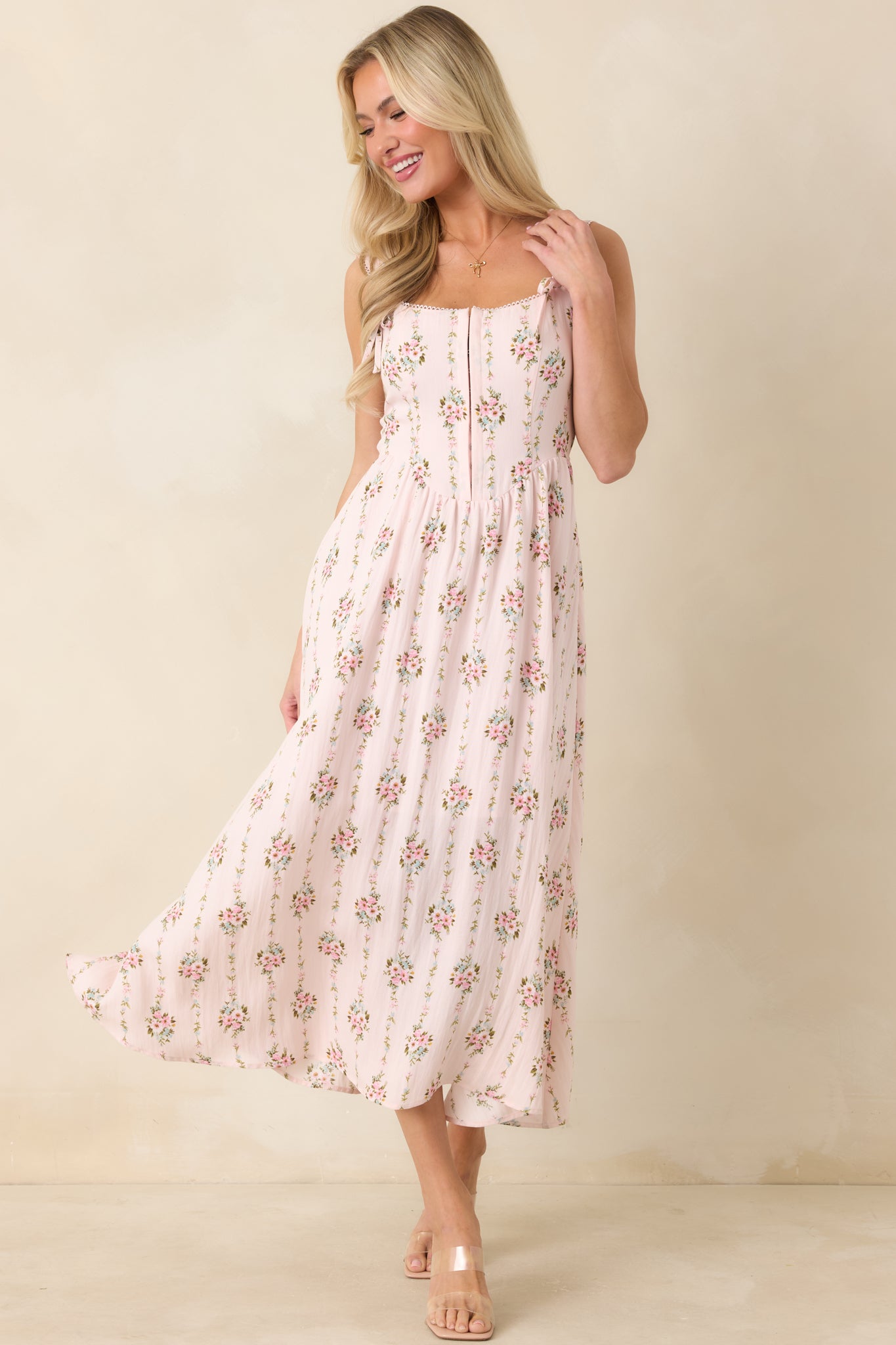 Light pink multi floral midi dress with hook and eye closures and softly structured silhouette.