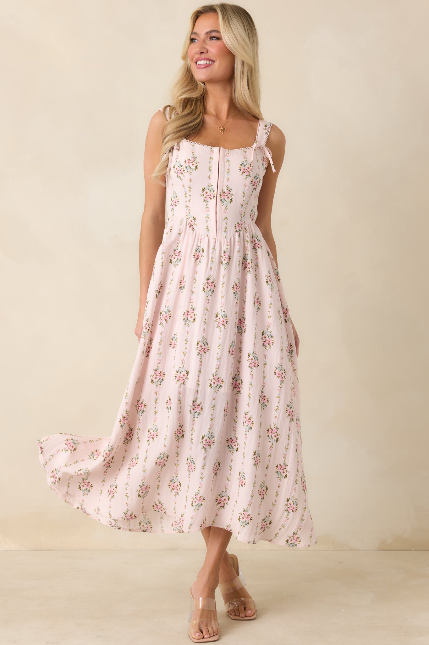 Light pink multi floral midi dress with delicate picot trim, hook and eye front, and softly contoured silhouette.