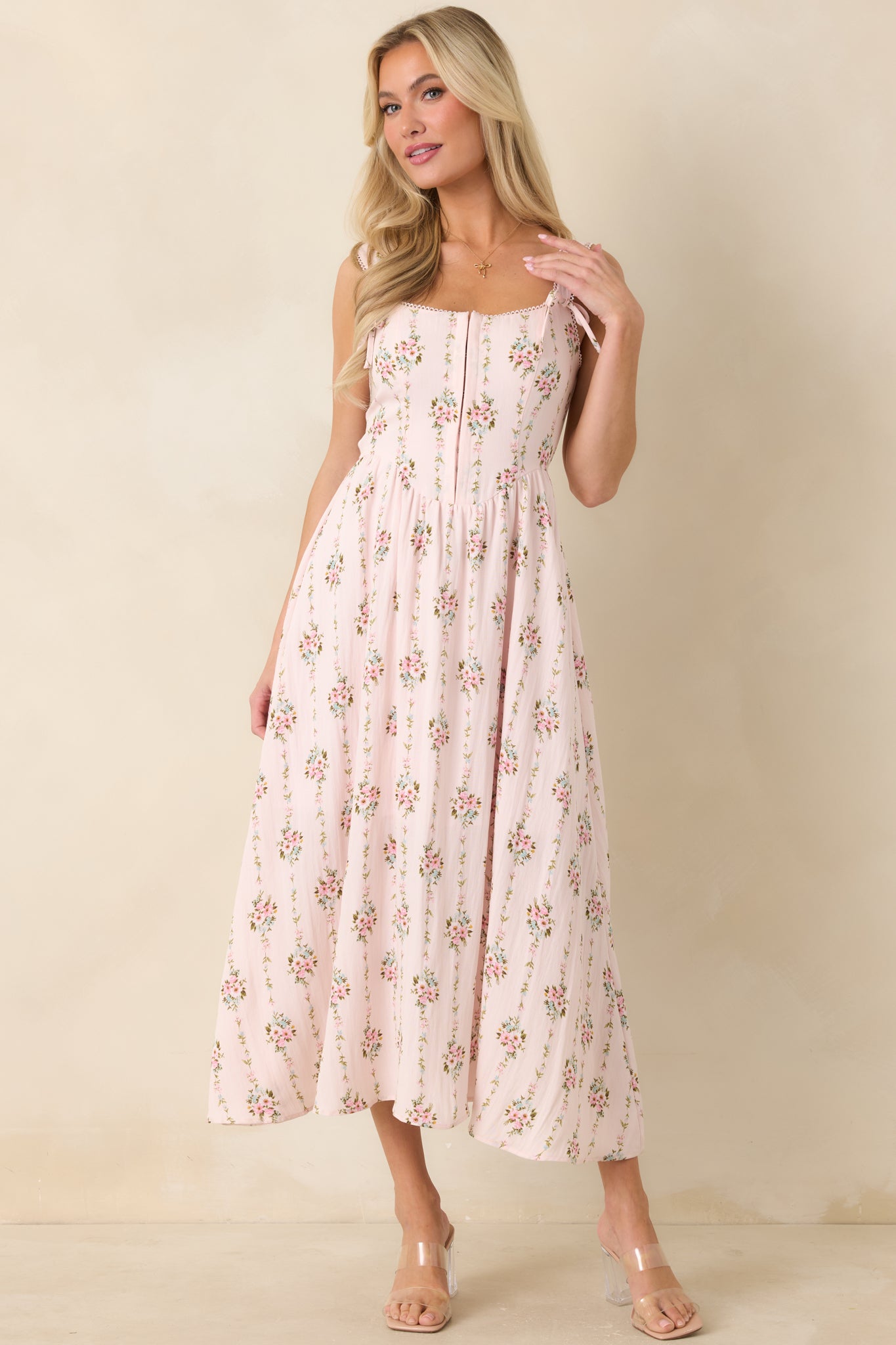 Light pink floral midi dress with picot edge trim, adjustable tie straps, and a refined shape.