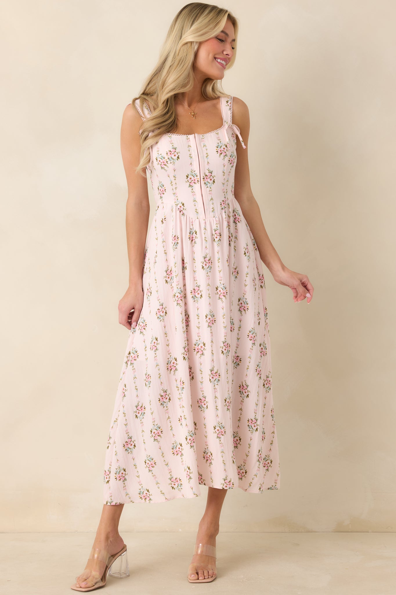 Light pink floral midi dress featuring hook and eye front closure and a gently sculpted silhouette.