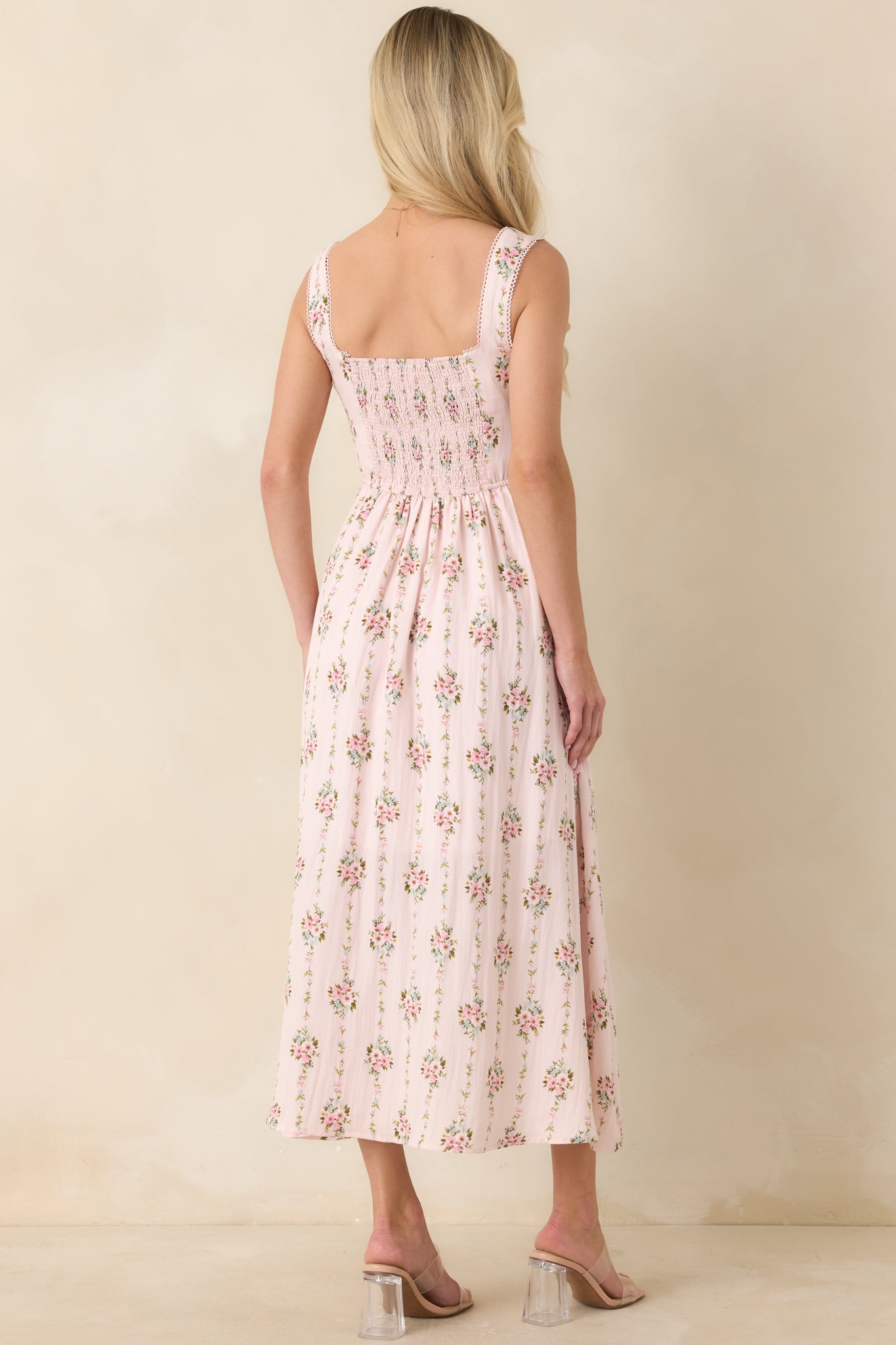 Rear view of light pink multi floral midi dress with softly structured silhouette and tie strap details.
