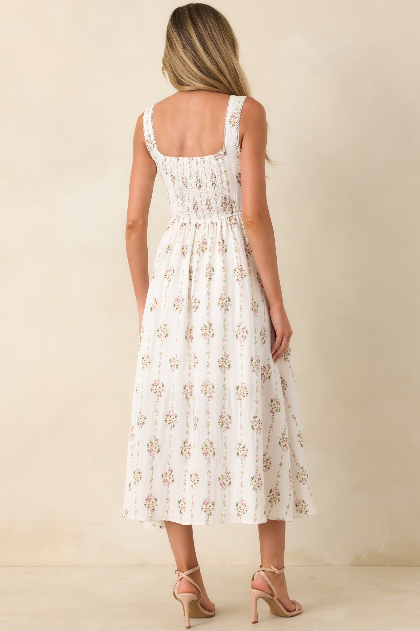 Rear view of the white multi floral midi dress featuring the softly structured silhouette, floral print, and midi-length design.