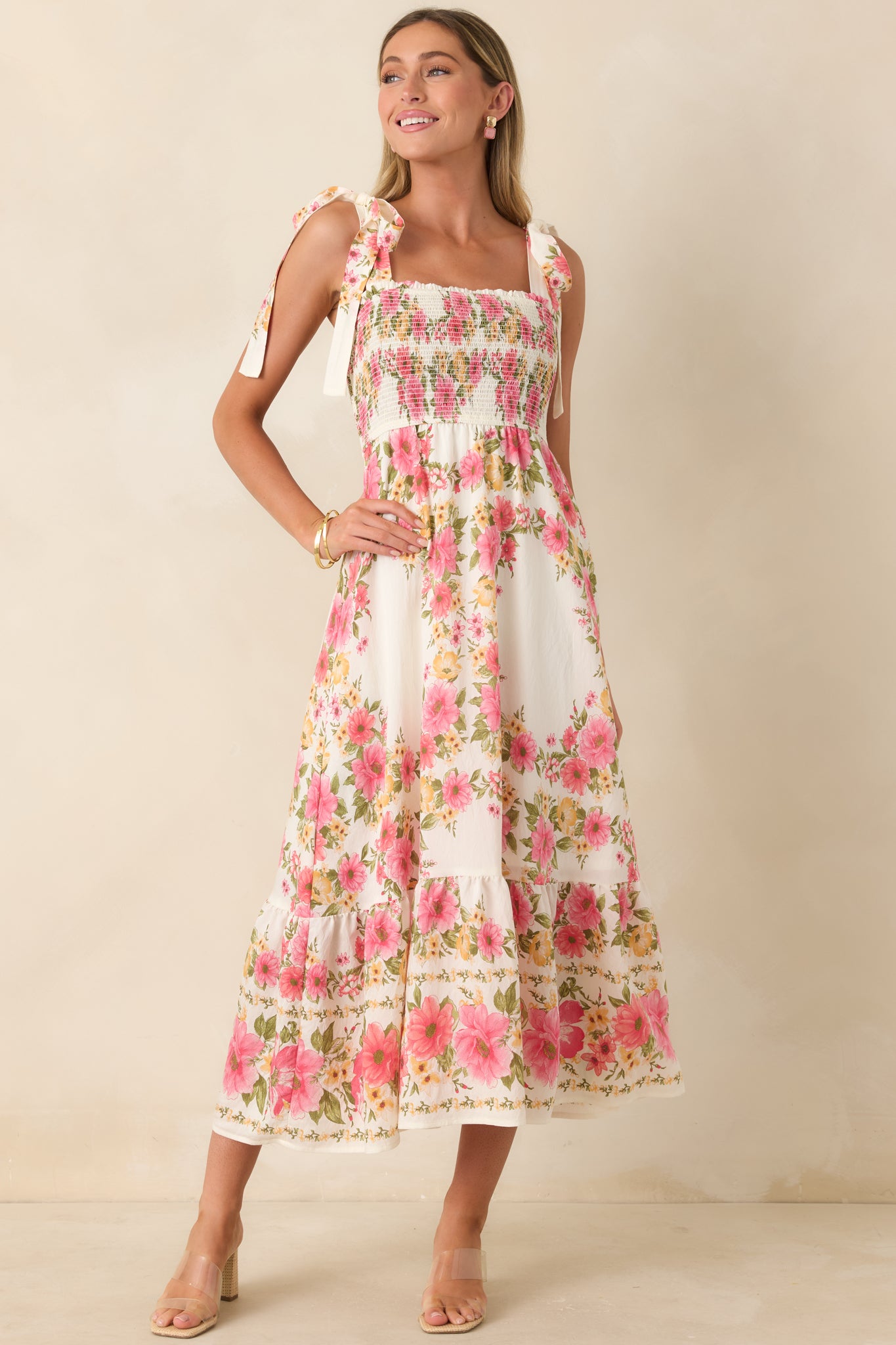 Pink and yellow floral midi dress with smocked bodice and flowy skirt silhouette.