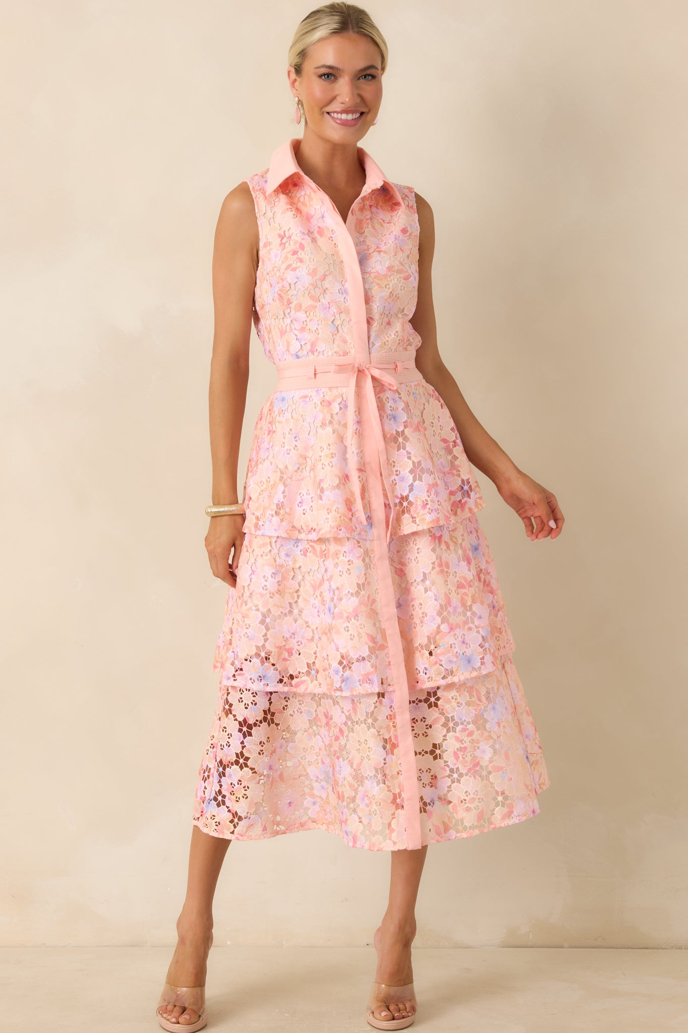 Pink lace overlay dress showcasing a lined interior, midi-length hem, and softly structured silhouette.