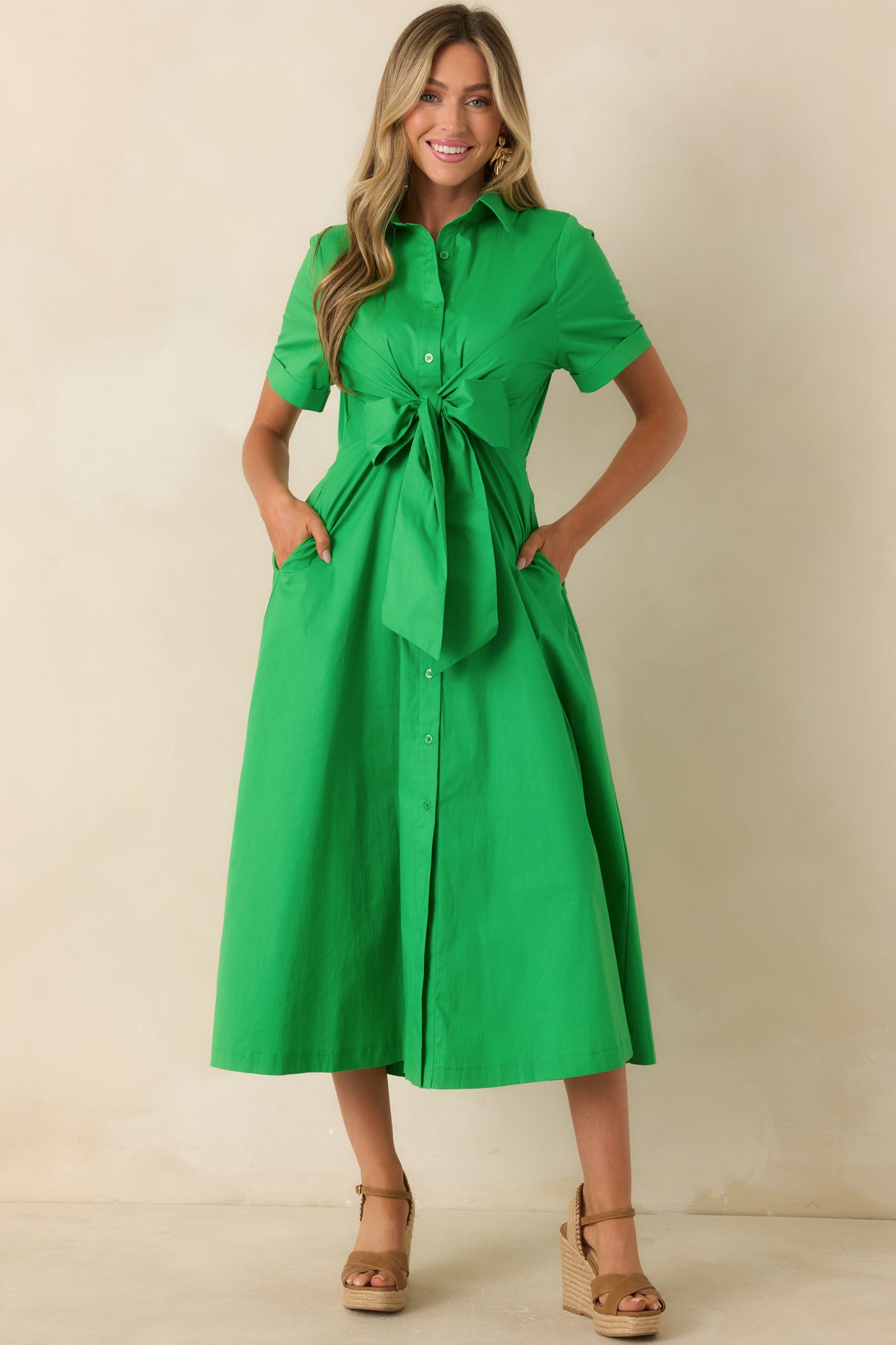 Green button-front midi dress with a tailored upper structure and voluminous skirt for balanced proportion.
