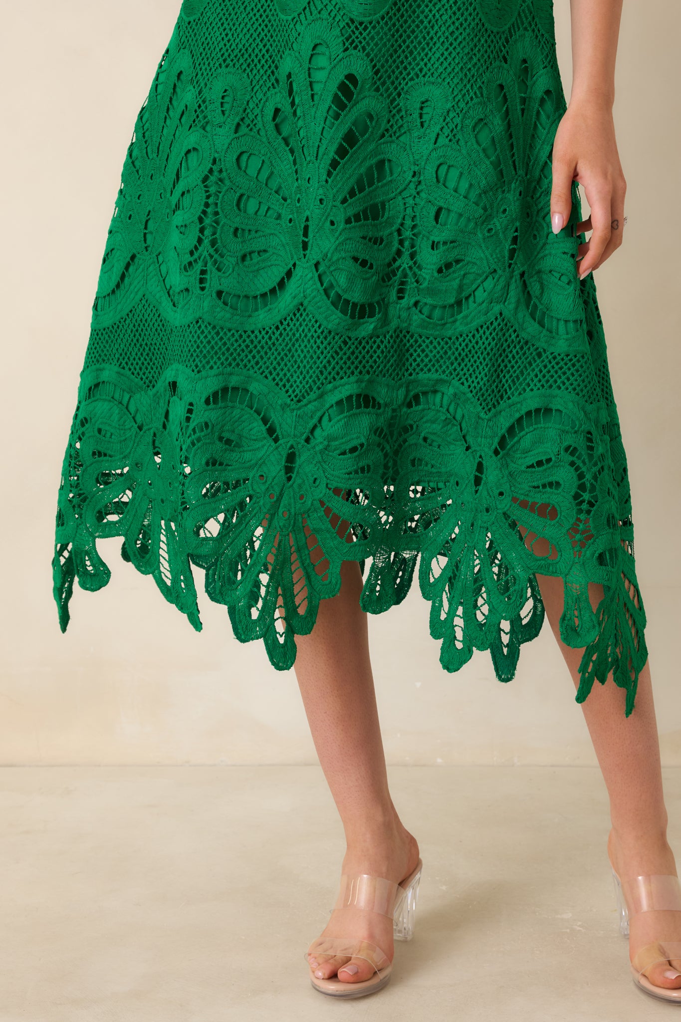 Detailed view of the intricate green lace pattern and scalloped hem.
