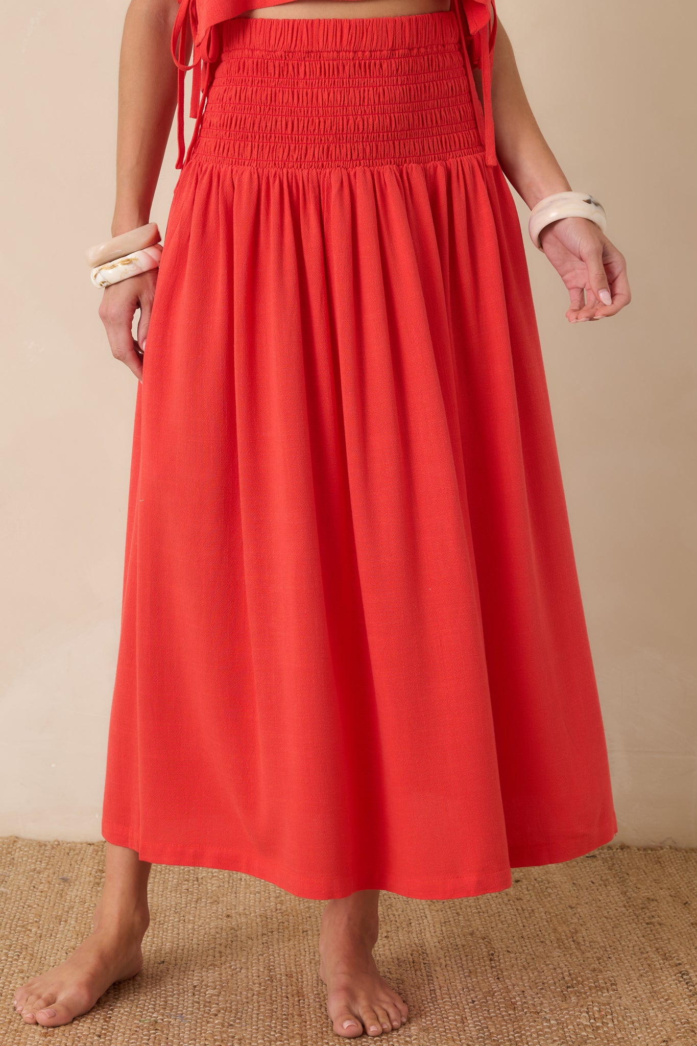 Front detail highlighting the textured smocked bodice and relaxed drape of the full-length silhouette.