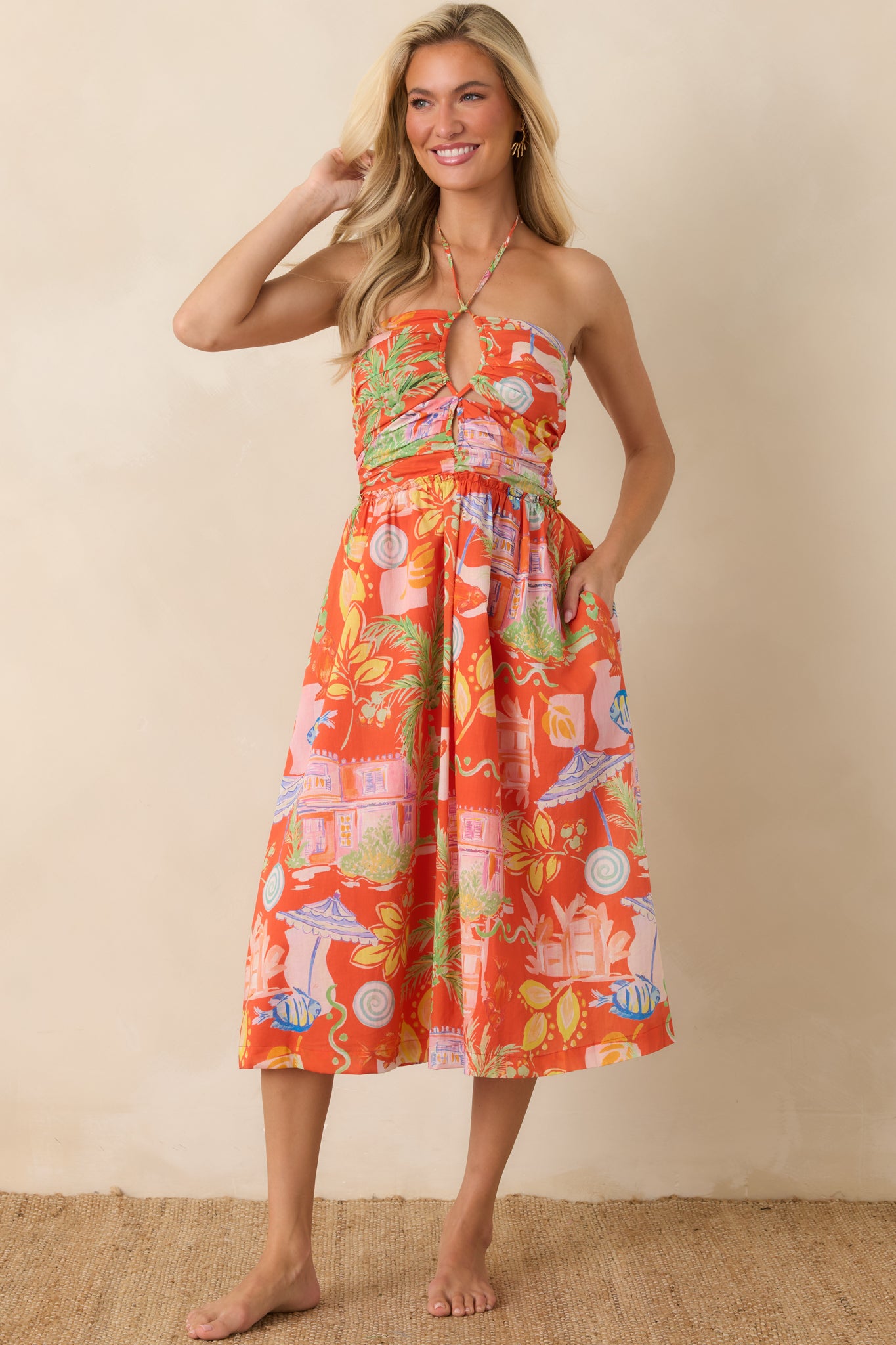 Orange multi midi dress featuring a smocked bodice, halter neckline with adjustable tie closure, and a flowy tiered skirt.