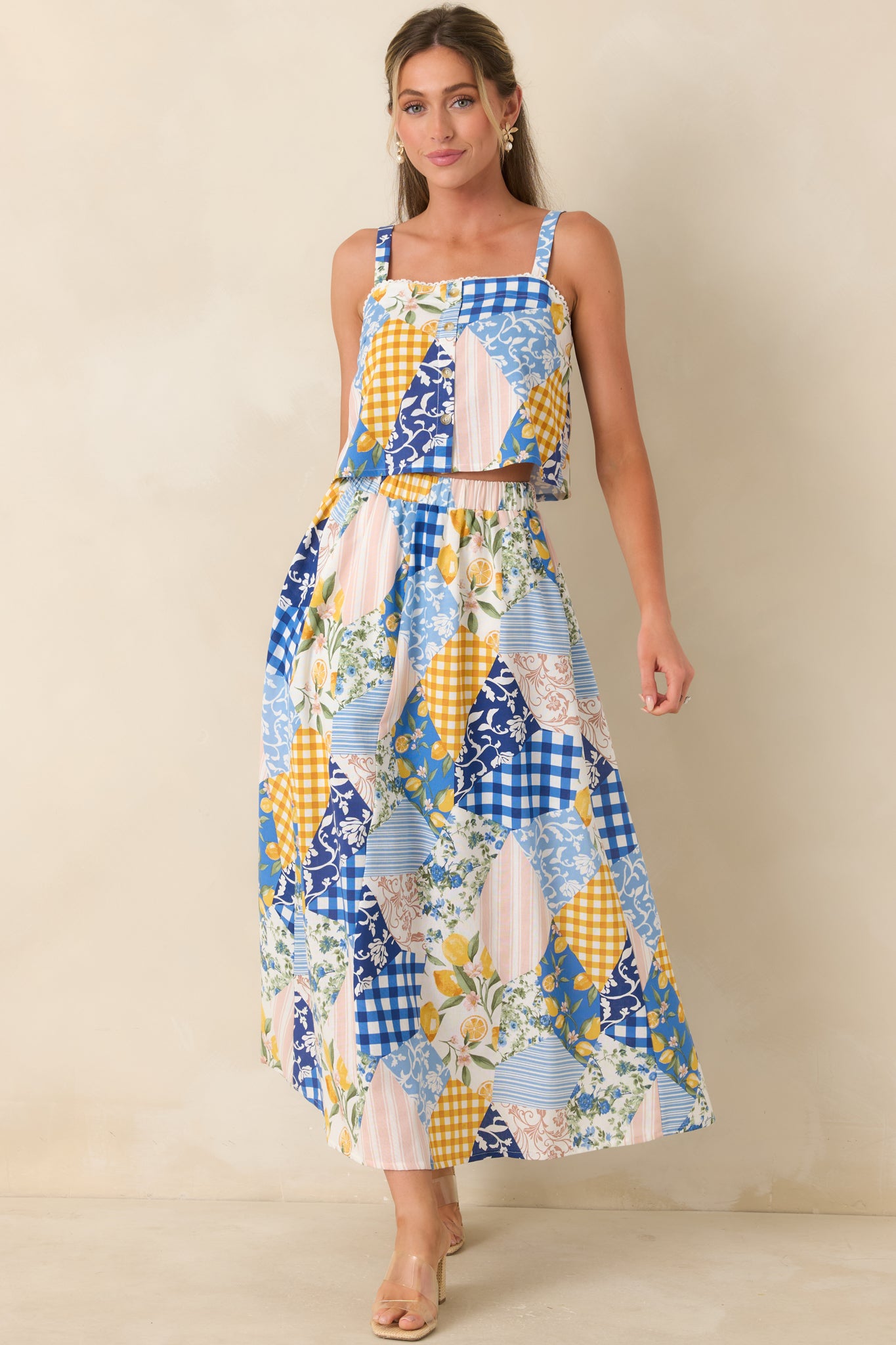 Blue multi cropped top with patchwork print, square neckline, and button front closure.